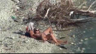 Couple banging on a public beach, while walking past people